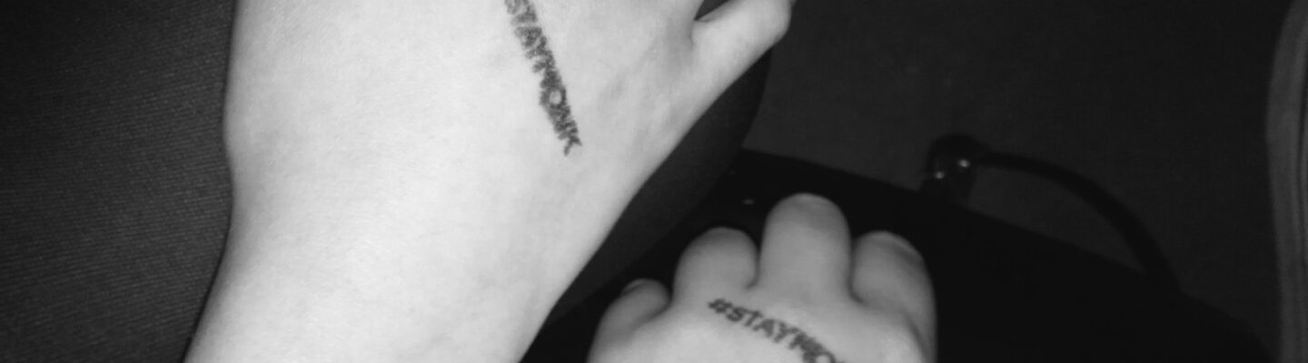 Foto che ritrae due mani con la scritta #StayMonk di un timbro